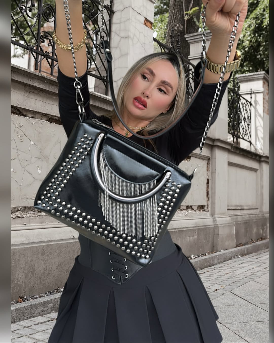 Bolso negro con detalles metálicos: Un accesorio llamativo y moderno para complementar tu estilo.