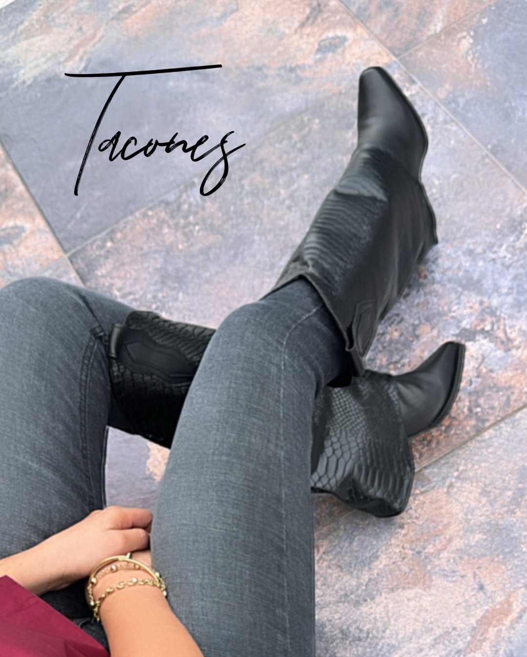 Bota alta de caña suave con punta afilada y detalles de textura tipo piel de serpiente en color negro.