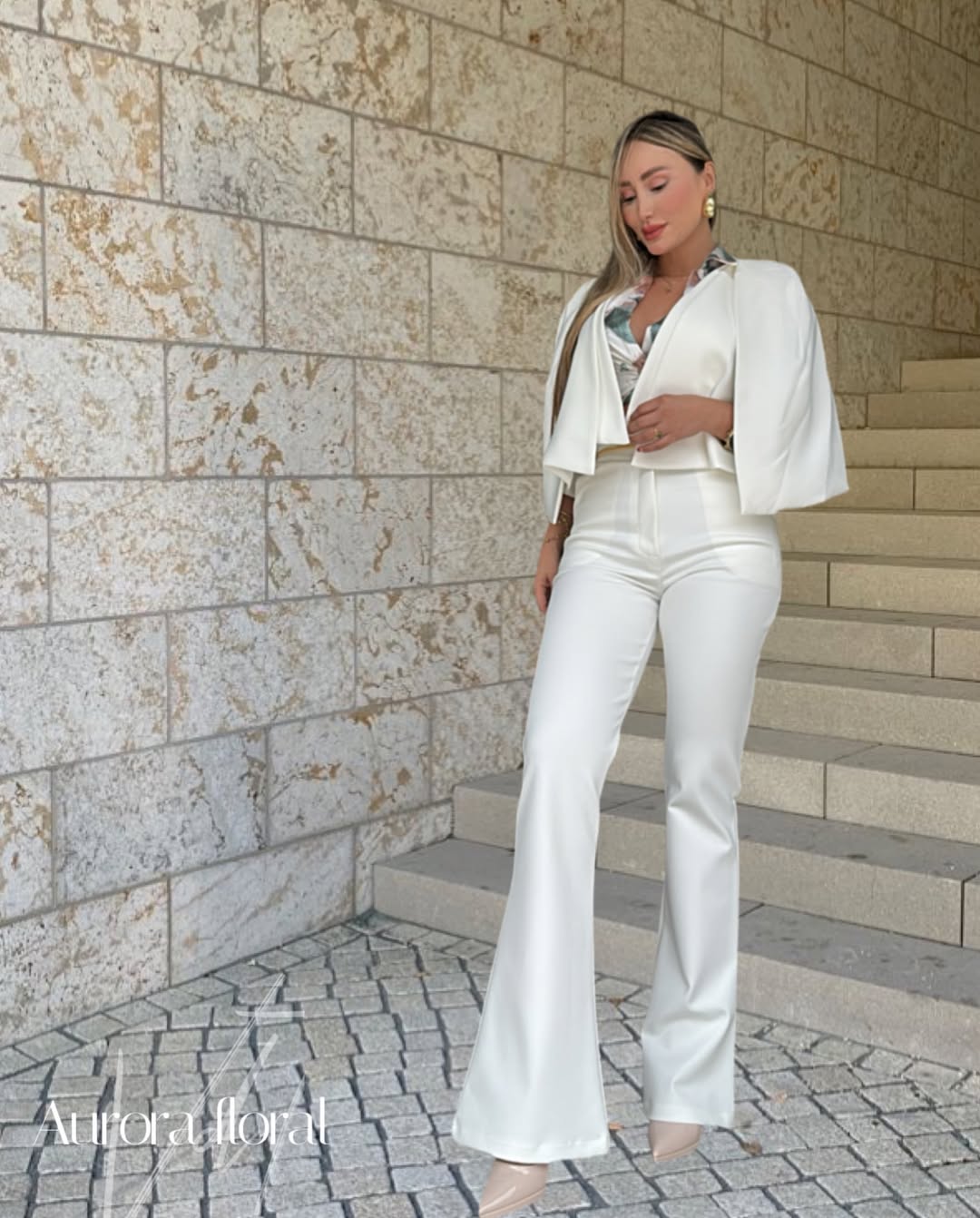 Capa corta blanca con caída fluida. Diseño abierto que aporta un toque sofisticado y moderno a tu look.